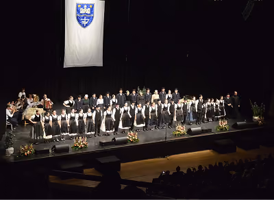A csoport teljes létszámban népviseletben a 10. jubileumi gála nagyszínpadán, felettük Pilisvörösvár címeres zászlaja, a színpad szélén virágcsokrokkal.
